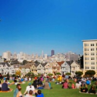 Die malerischen Painted Ladies, eine Reihe farbenfroher viktorianischer Häuser, mit der Skyline von San Francisco im Hintergrund.